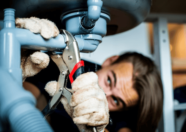 a plumber is fixing a leaking pipe